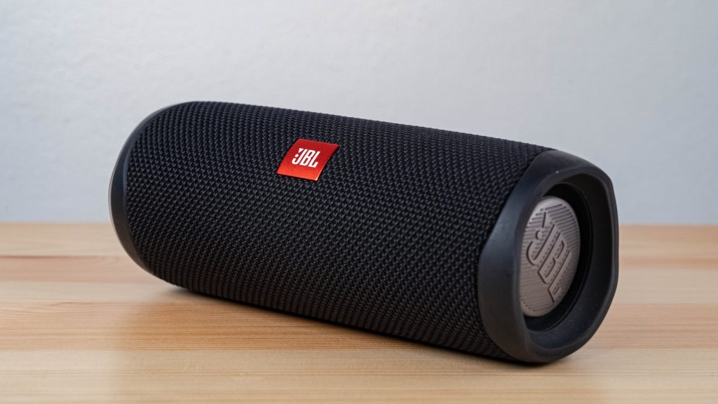 black jbl portable speaker on brown wooden table